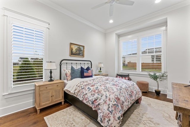 bedroom with crown molding, ceiling fan, dark wood-type flooring, and multiple windows