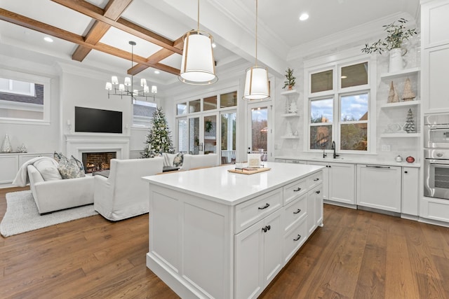 kitchen with coffered ceiling, white cabinetry, dark hardwood / wood-style floors, a kitchen island, and pendant lighting