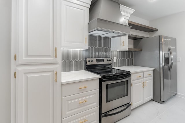 kitchen featuring tasteful backsplash, white cabinets, custom range hood, and appliances with stainless steel finishes