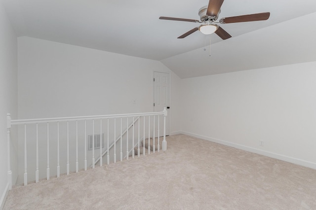 carpeted spare room featuring ceiling fan and lofted ceiling