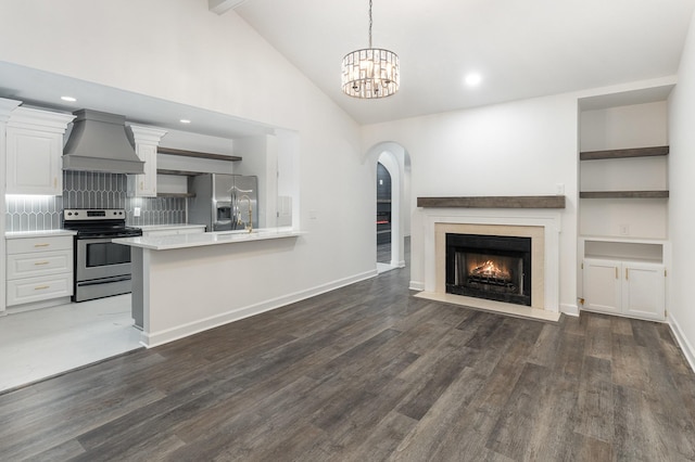 unfurnished living room with dark hardwood / wood-style flooring, high vaulted ceiling, and a chandelier