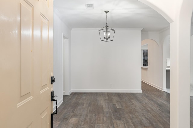 interior space featuring a chandelier, dark wood-type flooring, and ornamental molding