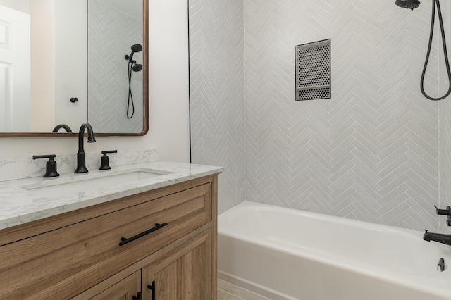 bathroom featuring vanity and tiled shower / bath