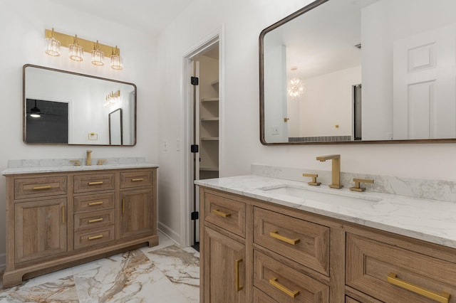 bathroom with vanity and ceiling fan with notable chandelier