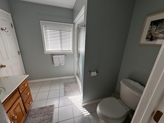 bathroom featuring toilet, vanity, tile patterned floors, and a shower with shower door