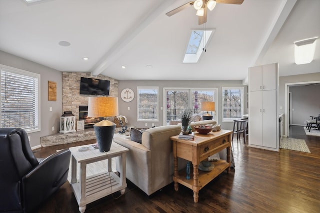 living room featuring dark hardwood / wood-style floors, a healthy amount of sunlight, and lofted ceiling with skylight