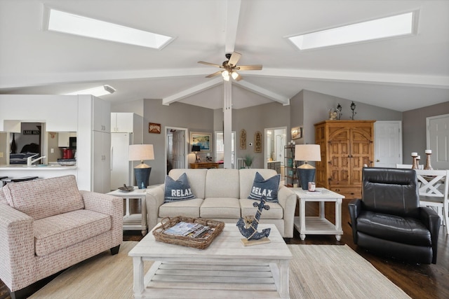 living room featuring ceiling fan, light wood-type flooring, and lofted ceiling with skylight