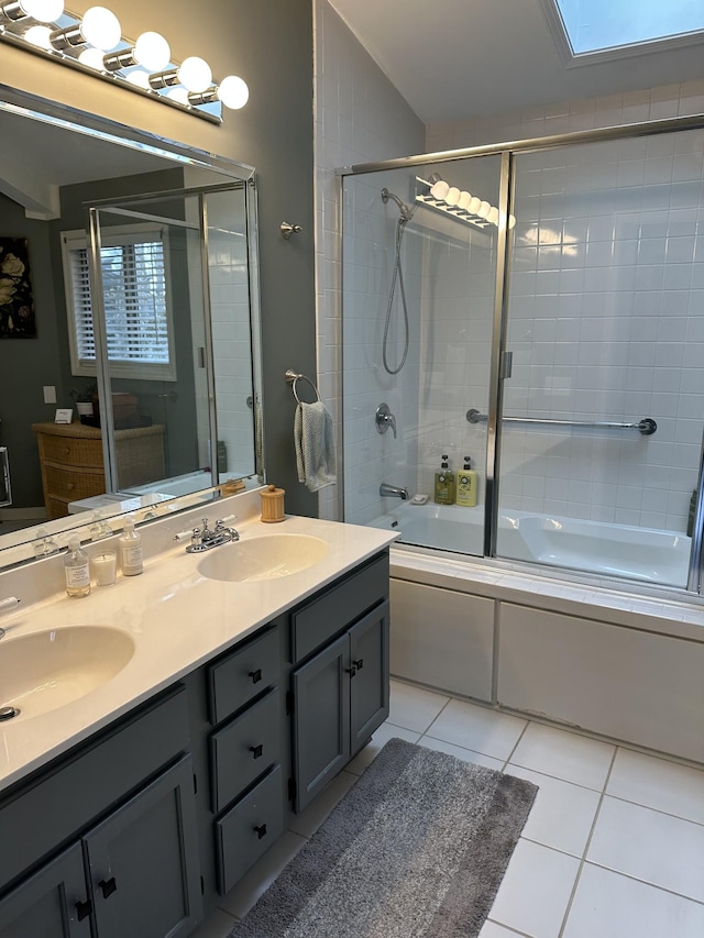 bathroom featuring tile patterned floors, a skylight, vanity, and bath / shower combo with glass door