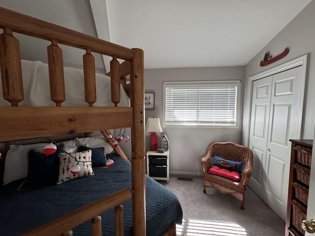 carpeted bedroom featuring a closet and lofted ceiling