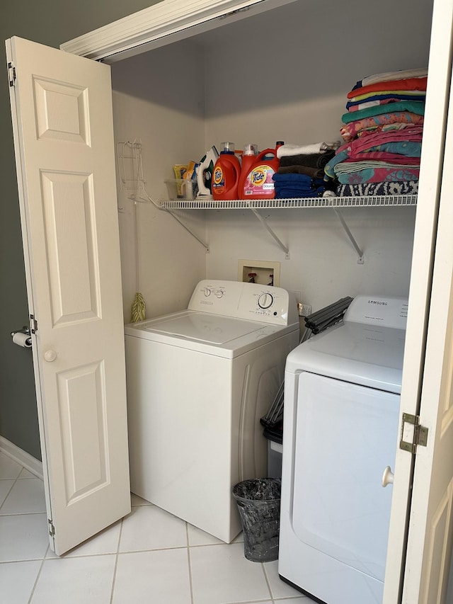 clothes washing area with washing machine and clothes dryer and light tile patterned floors