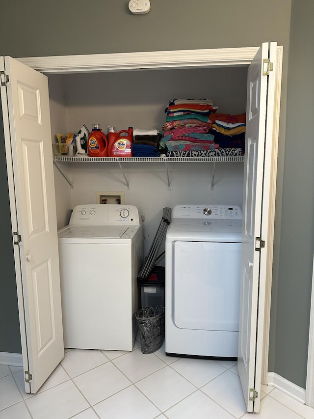 laundry room featuring washer and clothes dryer and light tile patterned flooring