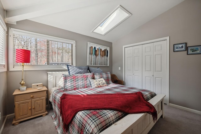 bedroom featuring dark carpet, lofted ceiling with skylight, and a closet