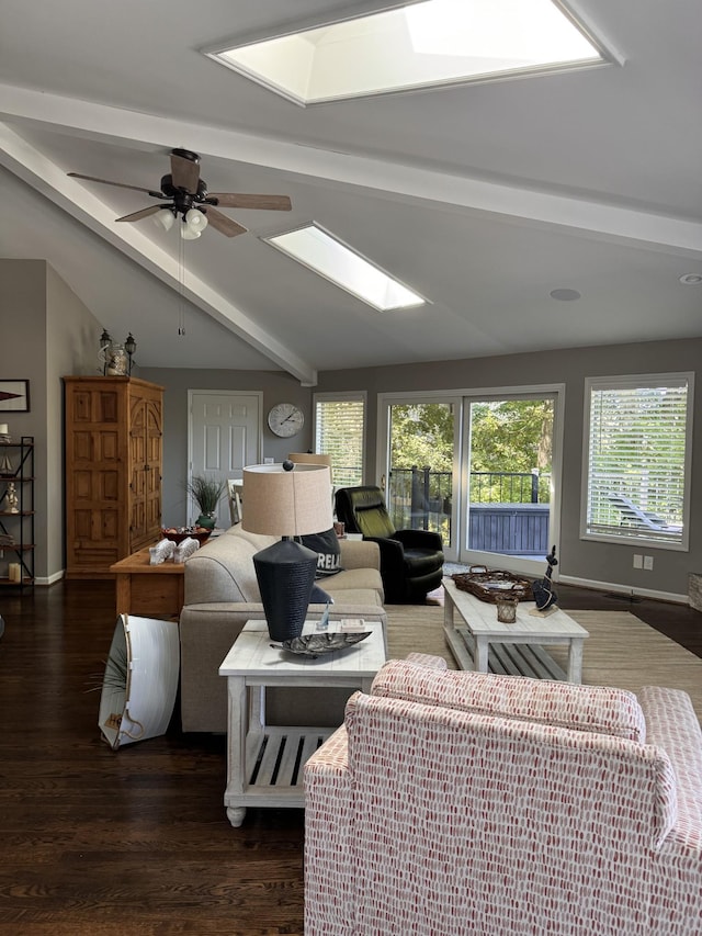 living room featuring vaulted ceiling with skylight, ceiling fan, and dark wood-type flooring