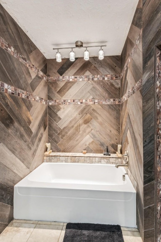 bathroom featuring tile patterned floors, a bathtub, and a textured ceiling