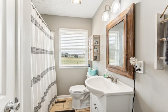 bathroom featuring tile patterned flooring, vanity, toilet, and a textured ceiling