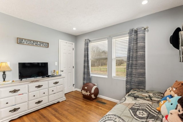 bedroom featuring hardwood / wood-style floors and a textured ceiling