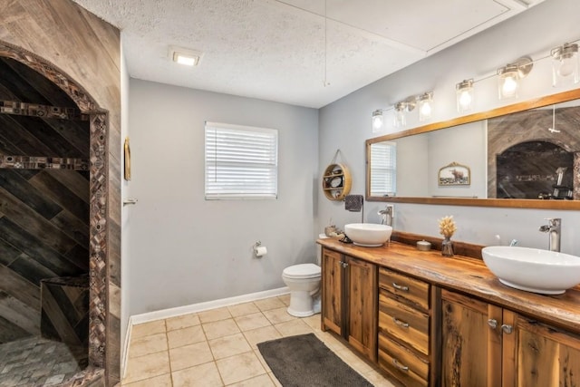 bathroom with vanity, a shower, tile patterned floors, toilet, and a textured ceiling