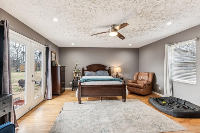 bedroom featuring ceiling fan, access to exterior, light wood-type flooring, and multiple windows