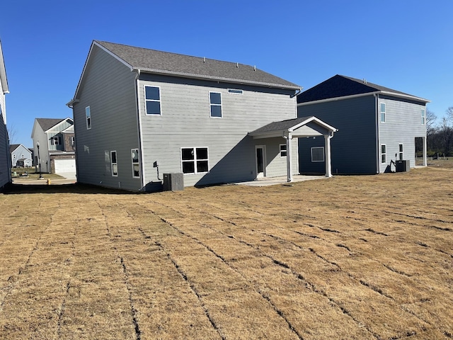 back of house featuring a lawn, central air condition unit, and a patio