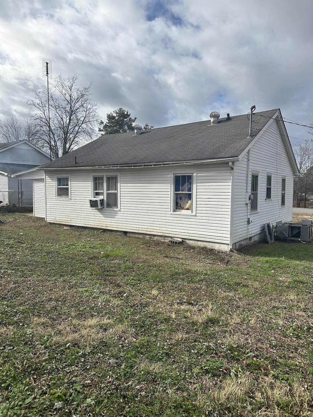 rear view of house featuring a yard and cooling unit