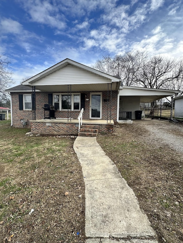 view of front of house with a carport, covered porch, and a front yard