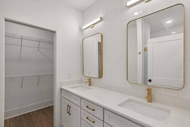 bathroom with hardwood / wood-style floors, vanity, decorative backsplash, and tile walls