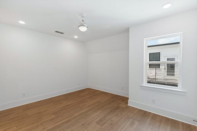 empty room with ceiling fan and light hardwood / wood-style flooring