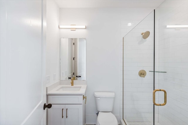 bathroom with vanity, toilet, and a shower with shower door