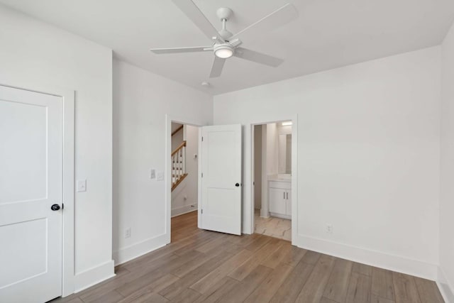 unfurnished bedroom with connected bathroom, ceiling fan, and light hardwood / wood-style flooring