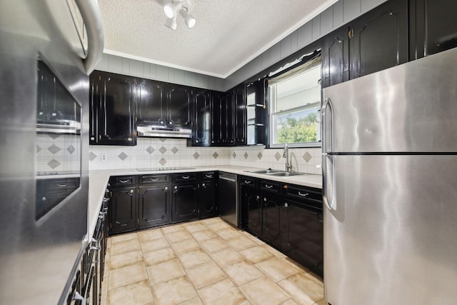 kitchen with a textured ceiling, stainless steel appliances, ornamental molding, and sink