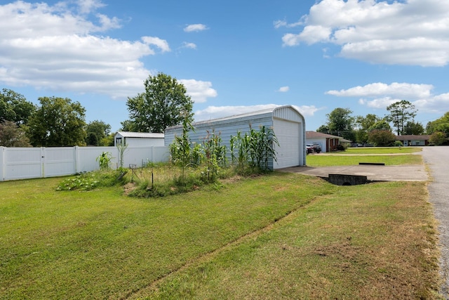 view of yard featuring a garage and an outdoor structure