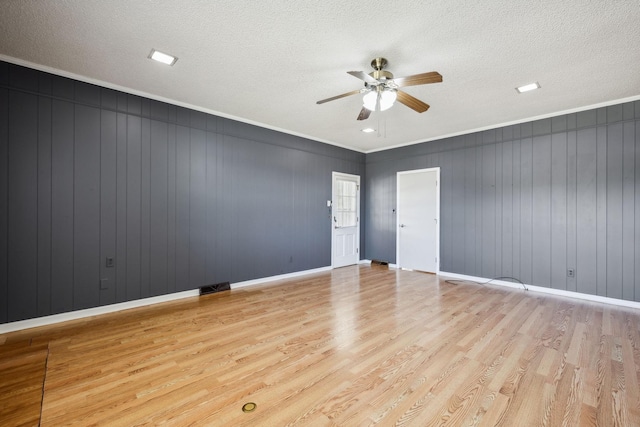 unfurnished room featuring ornamental molding, a textured ceiling, and light wood-type flooring