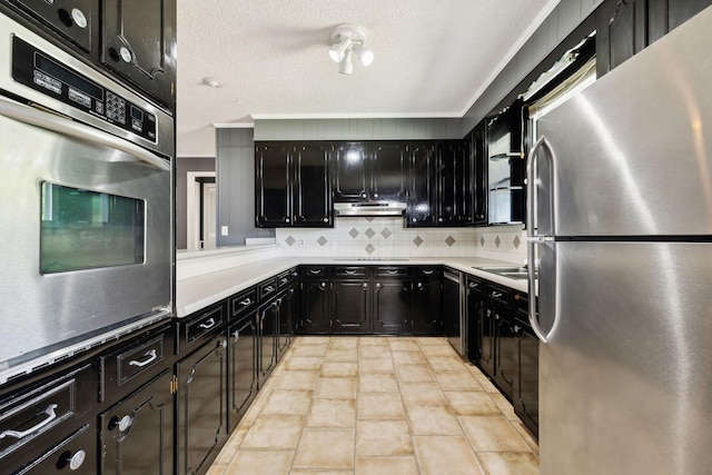 kitchen featuring decorative backsplash, light tile patterned floors, a textured ceiling, and stainless steel appliances