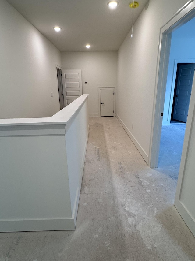 hallway featuring an upstairs landing, recessed lighting, and baseboards