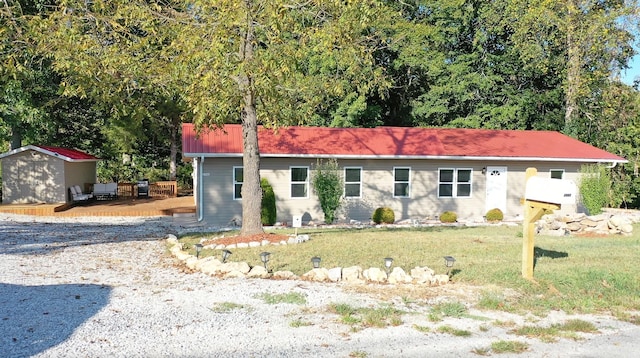 ranch-style house with a front lawn and a storage shed