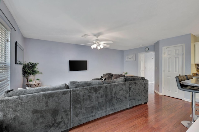 living room featuring ceiling fan and dark hardwood / wood-style floors