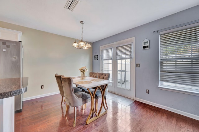 dining area featuring a chandelier and dark hardwood / wood-style flooring