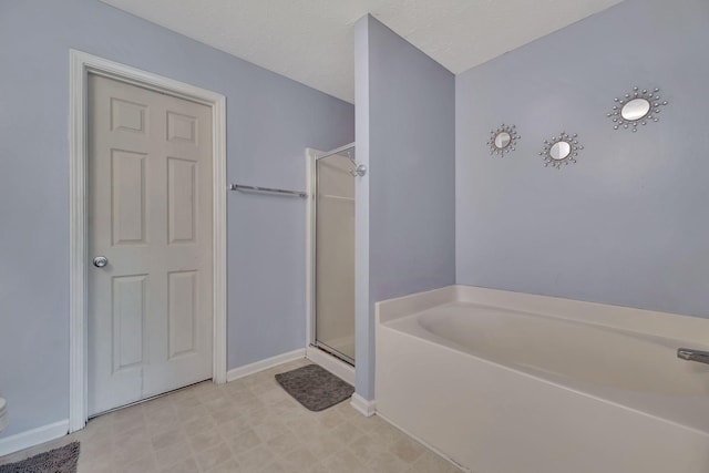 bathroom featuring a textured ceiling and separate shower and tub