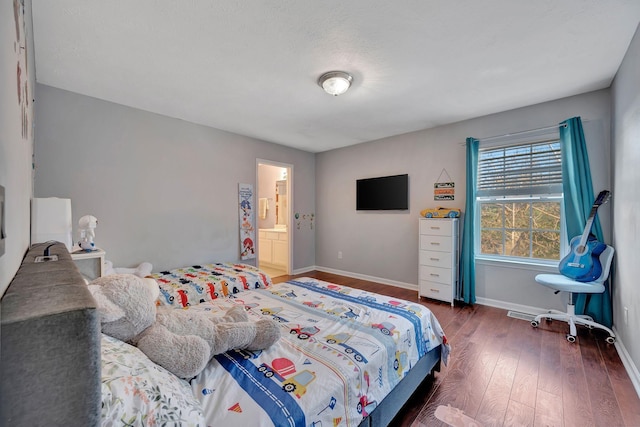 bedroom featuring dark hardwood / wood-style floors and ensuite bathroom