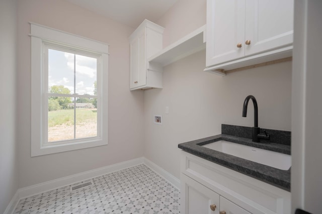 washroom featuring washer hookup, cabinets, sink, and a wealth of natural light