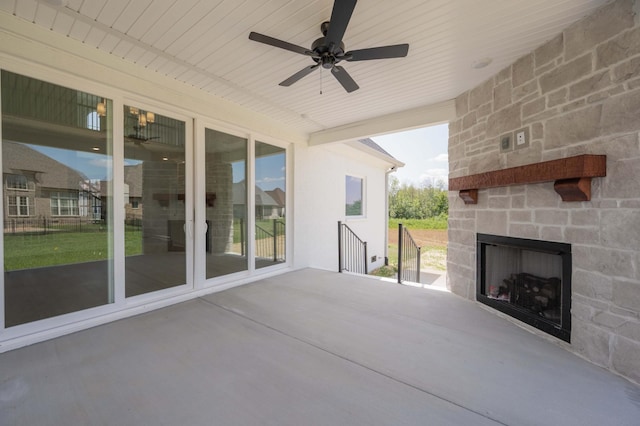 view of patio / terrace with ceiling fan and an outdoor stone fireplace