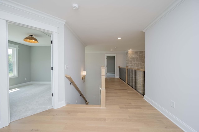 hall with light wood-type flooring and crown molding