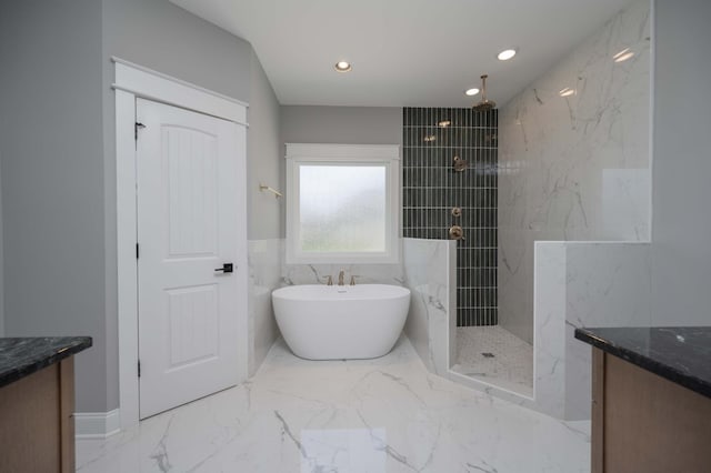 bathroom featuring plus walk in shower, vanity, and tile walls