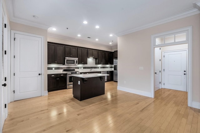 kitchen with a kitchen bar, decorative backsplash, stainless steel appliances, sink, and a center island