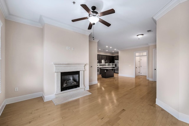 unfurnished living room featuring light wood-type flooring, ceiling fan, and crown molding