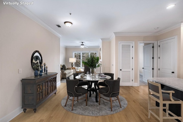 dining area featuring ceiling fan, light hardwood / wood-style floors, and ornamental molding