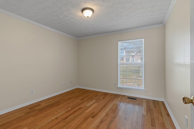 empty room with light wood-type flooring, ornamental molding, a textured ceiling, and plenty of natural light