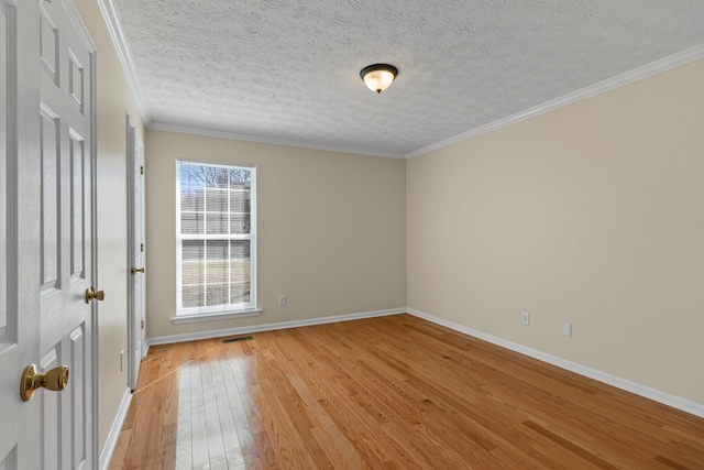 spare room with crown molding, a textured ceiling, and light hardwood / wood-style floors