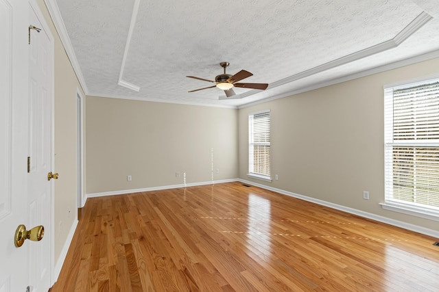 unfurnished room featuring light wood-type flooring, a healthy amount of sunlight, and crown molding