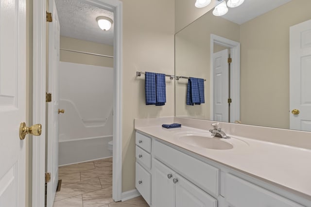 full bathroom with a textured ceiling, shower / tub combination, vanity, and toilet